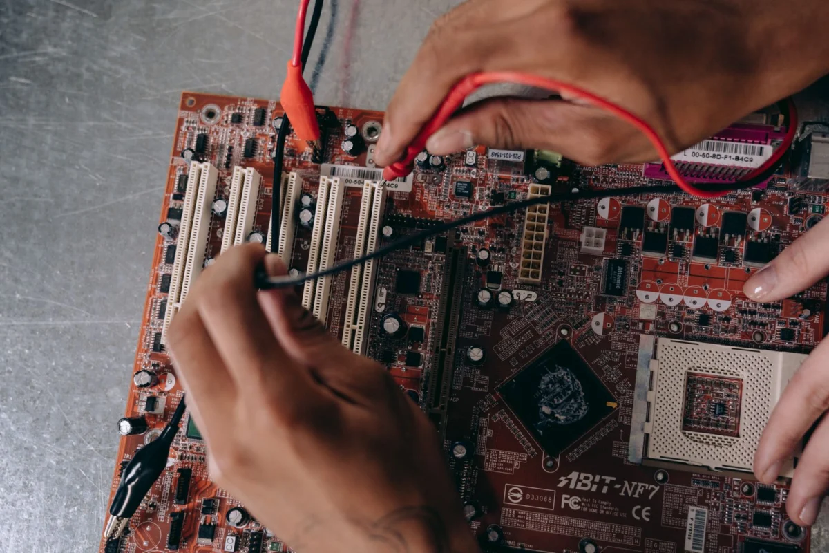 Hände arbeiten an einer Computerplatine