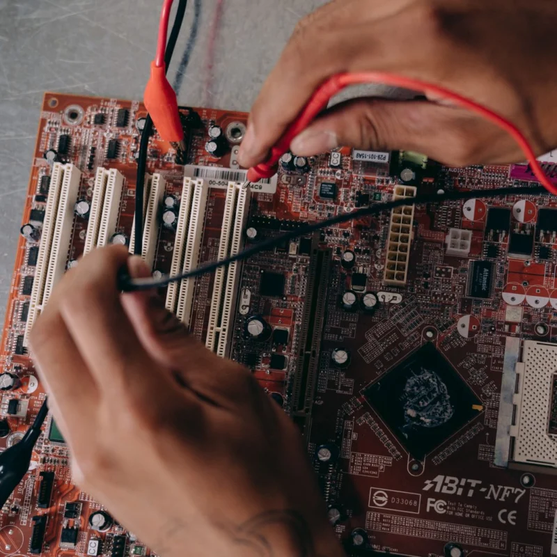 Hände arbeiten an einer Computerplatine
